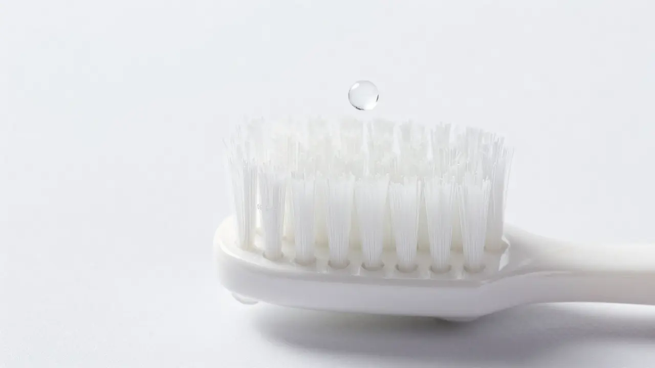 Detail měkkých polyamidových štětin Curaprox CS 5464 na bílé keramické ploše.